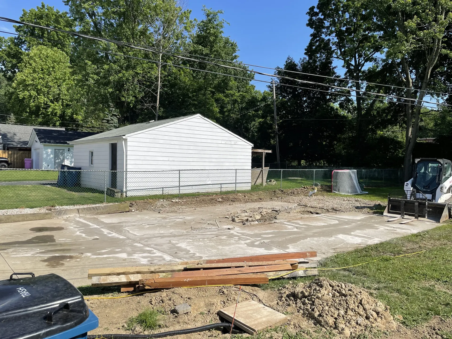 Demolished garage slab with skid steer